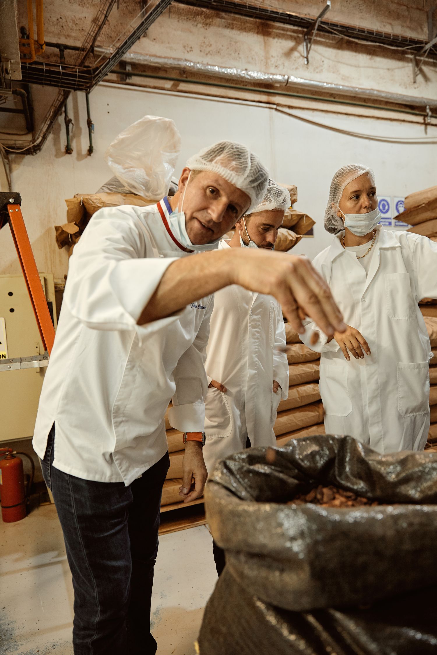 Philippe Chatelain et un opérateur avec les sacs de fèves